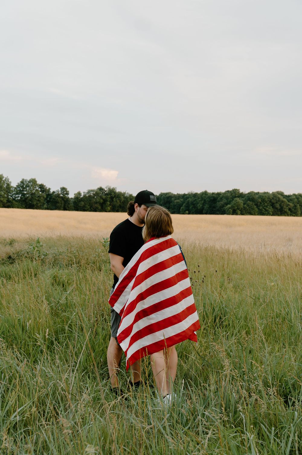A series of photos showing a person wrapped in an American flag standing in a grassy meadow at sunset.