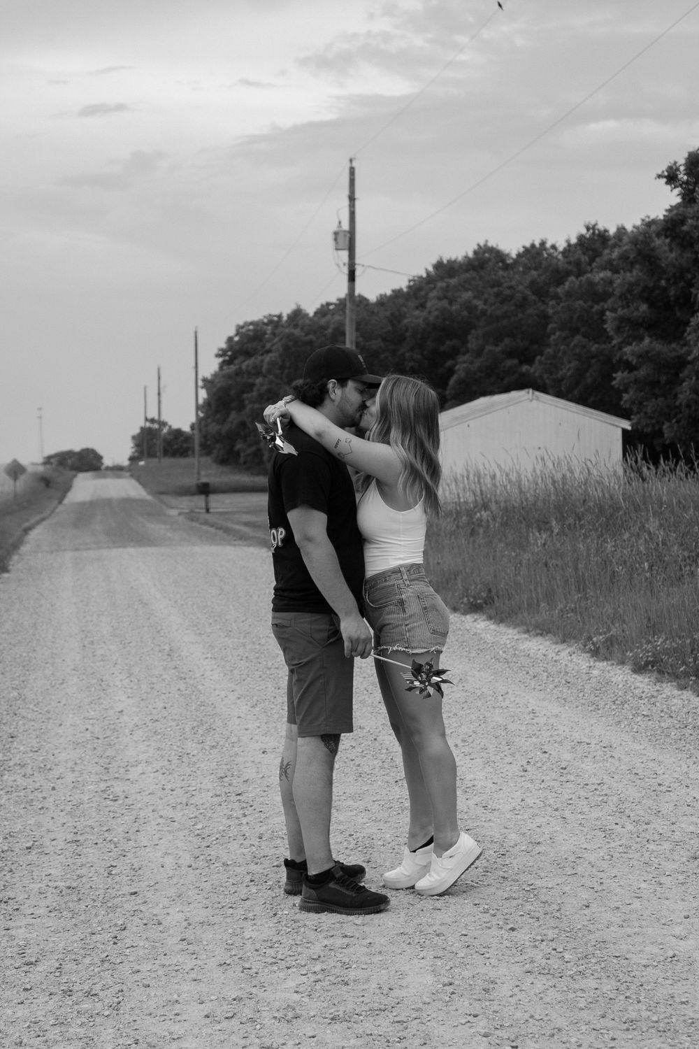 A romantic sequence of black and white photos showing a couple embracing on a rural gravel road.