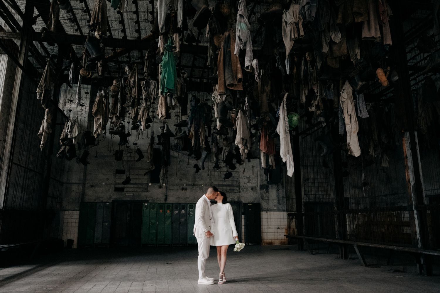 Dark indoor venue with dramatic overhead lighting and hanging decorative elements.