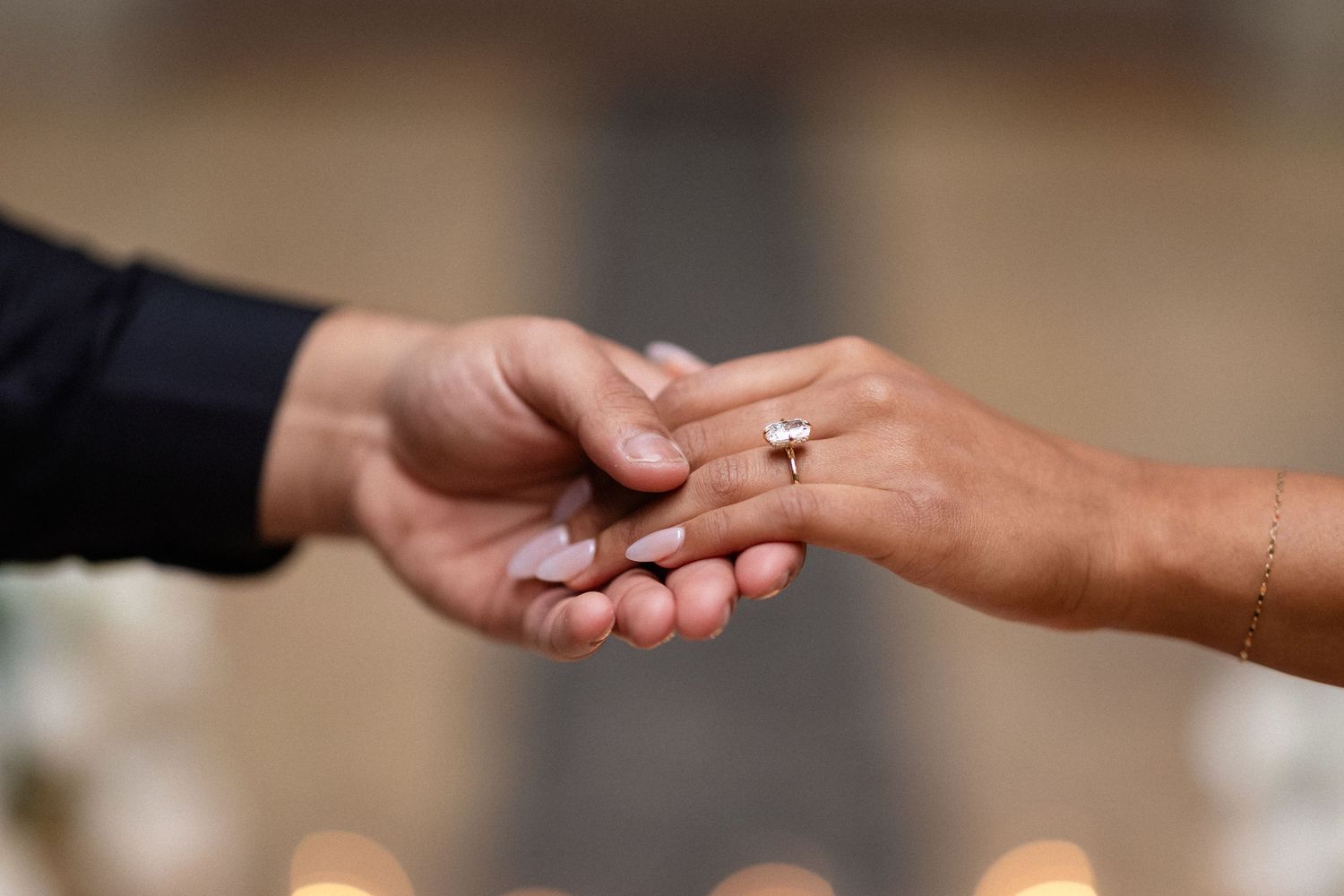 Close-up shot of hands exchanging a ring during a wedding ceremony.