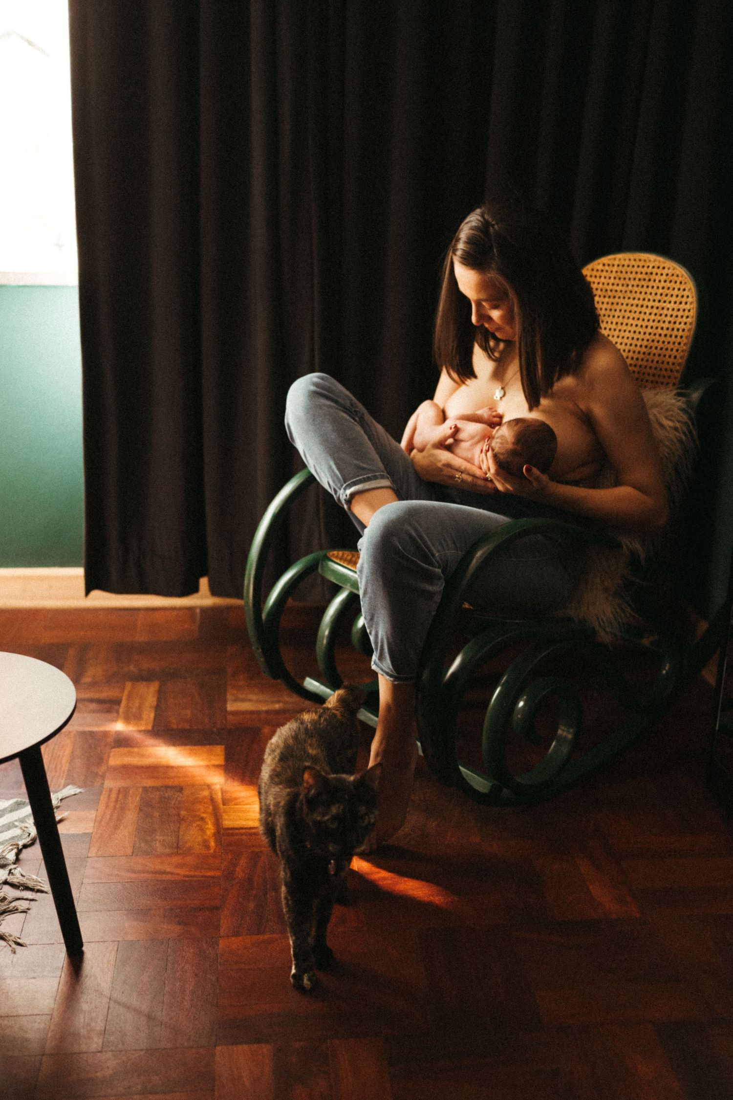 Dramatic low-light photos of a couple in an intimate moment on a wooden chair.