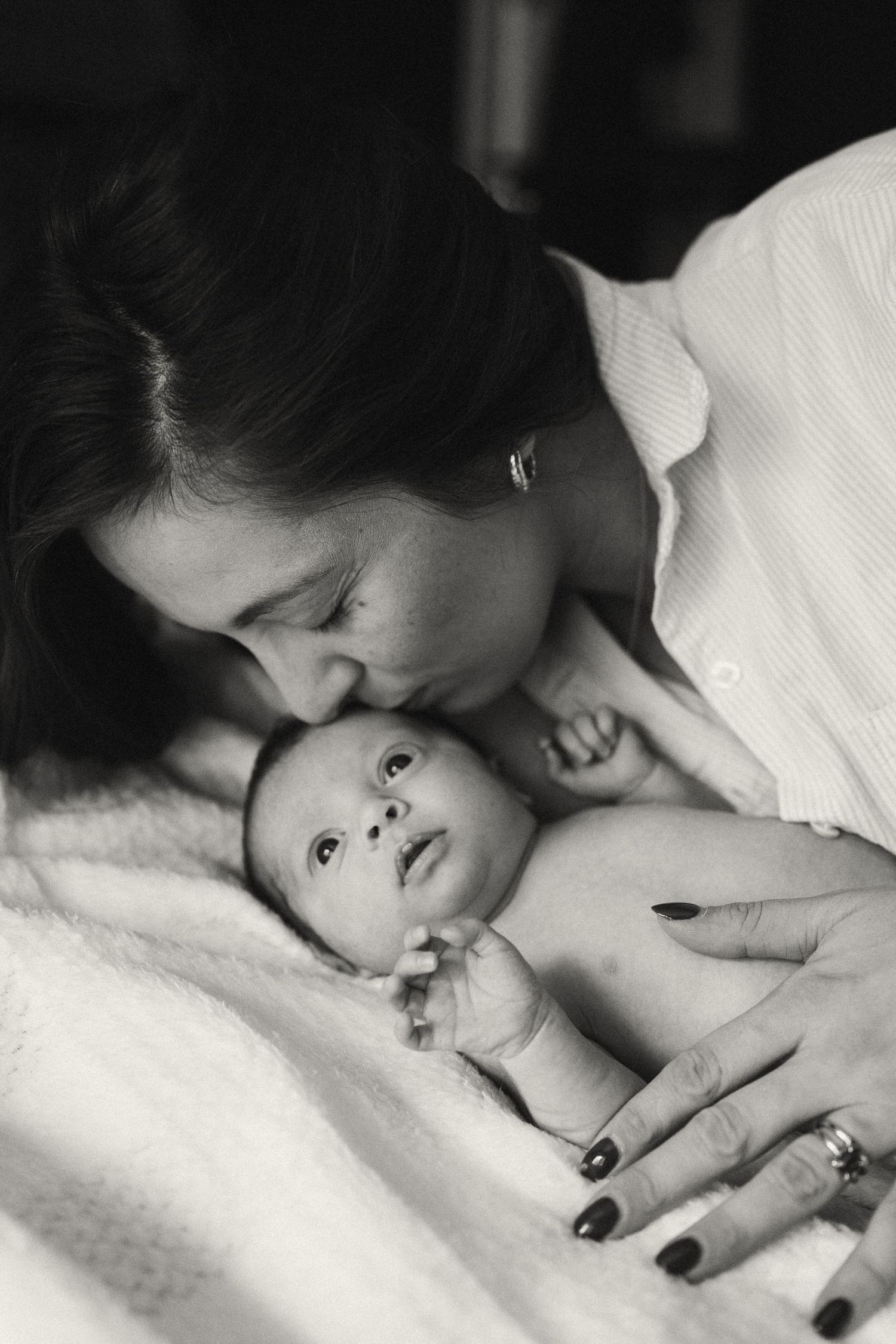 Intimate black and white photo of mother and baby sharing sweet moment.