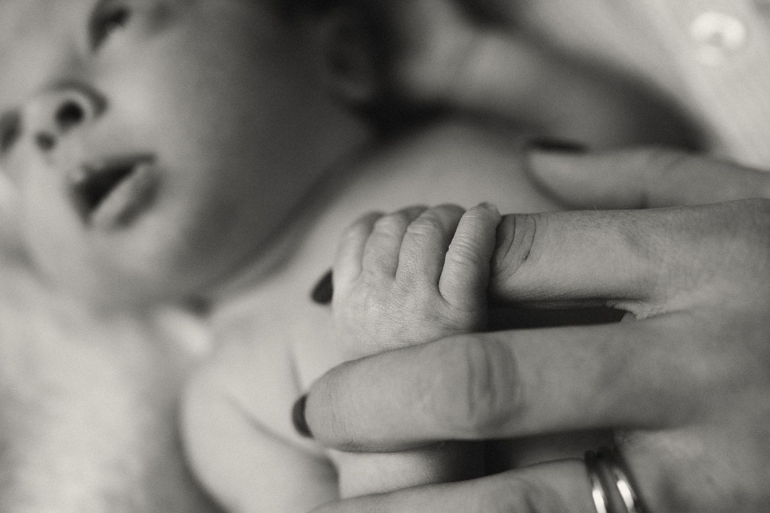 Close-up black and white image of mother and baby interaction.