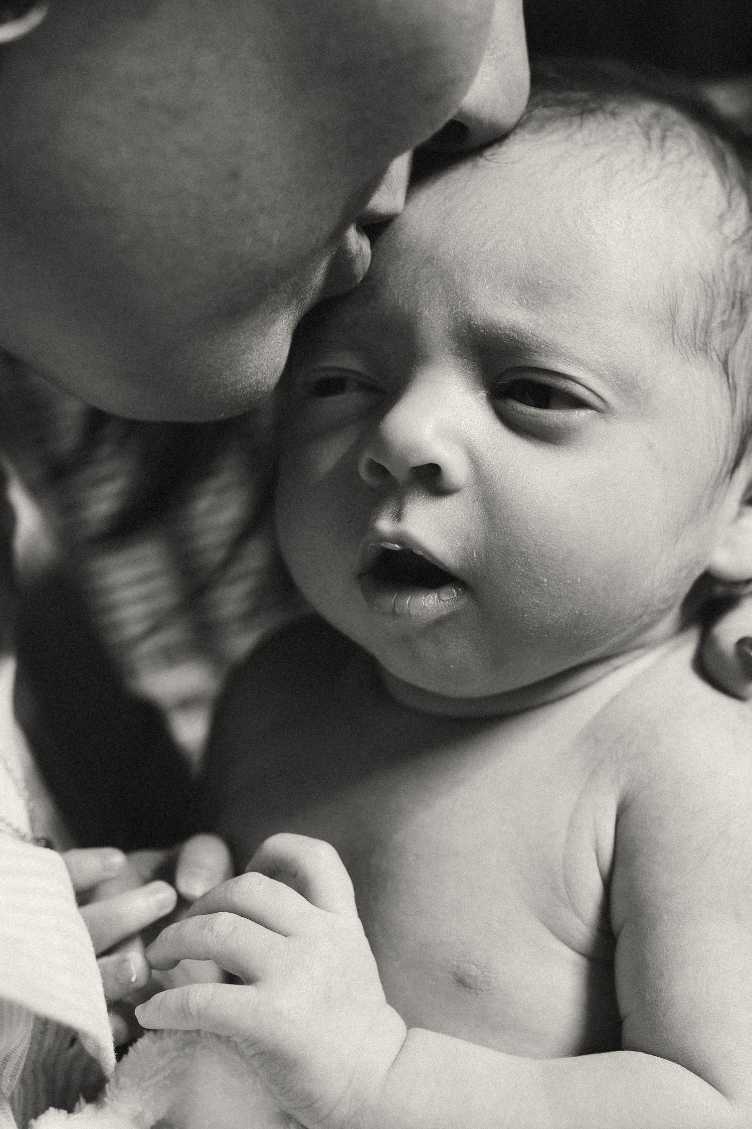 Black and white sequence showing sweet interaction between parent and infant.