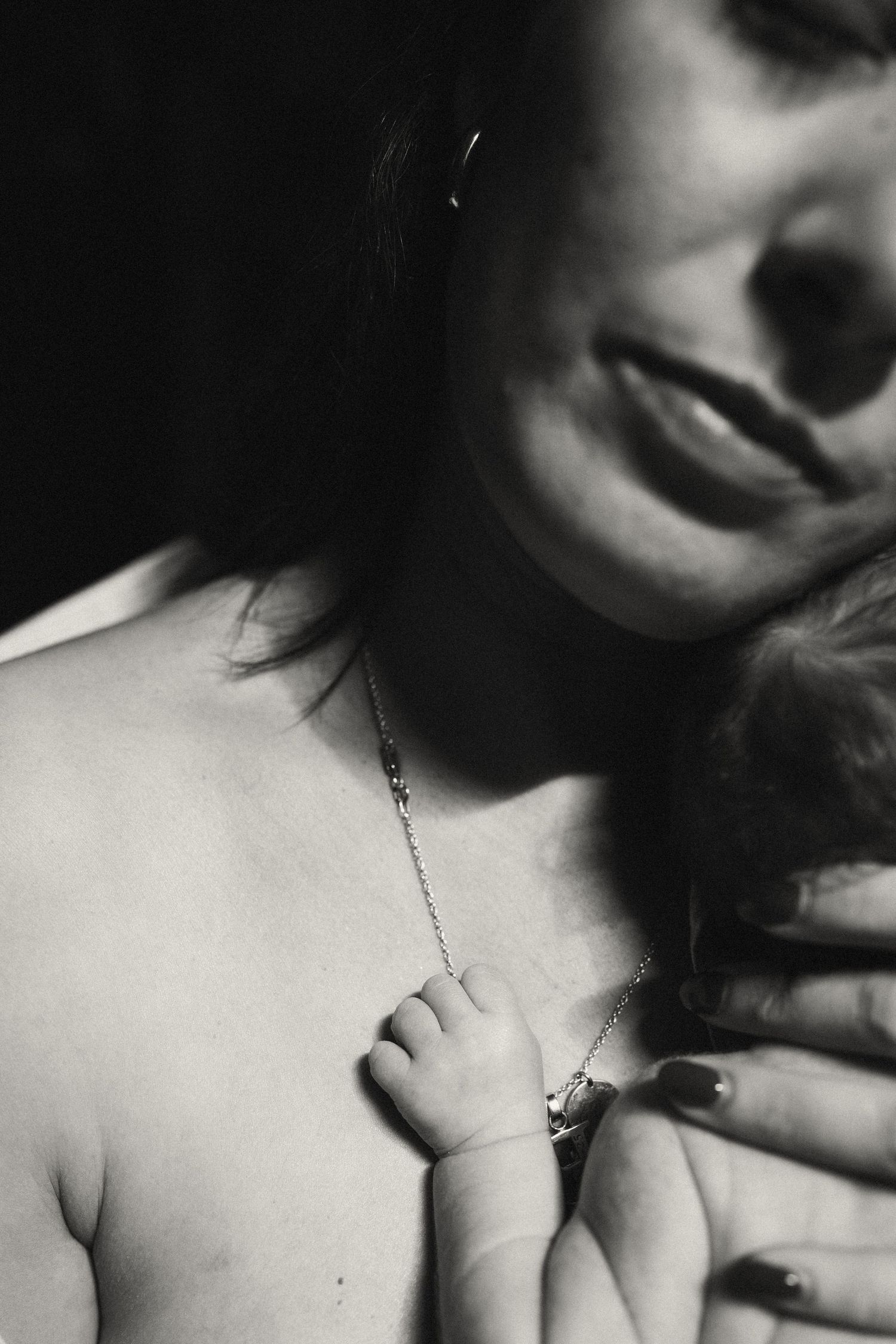 Intimate black and white close-up of parent and baby bonding.