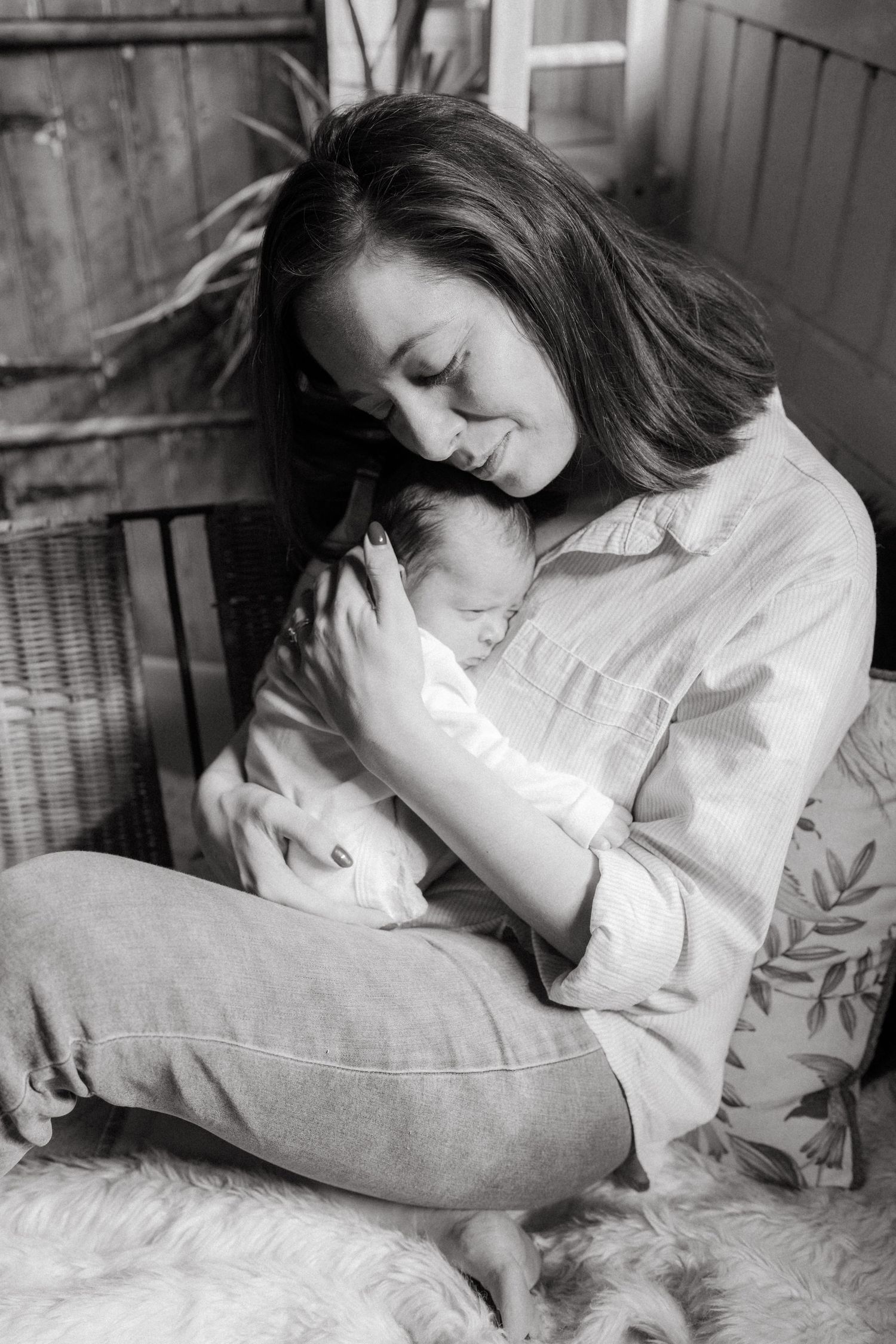 Tender moments between mother and newborn captured in black and white photography.
