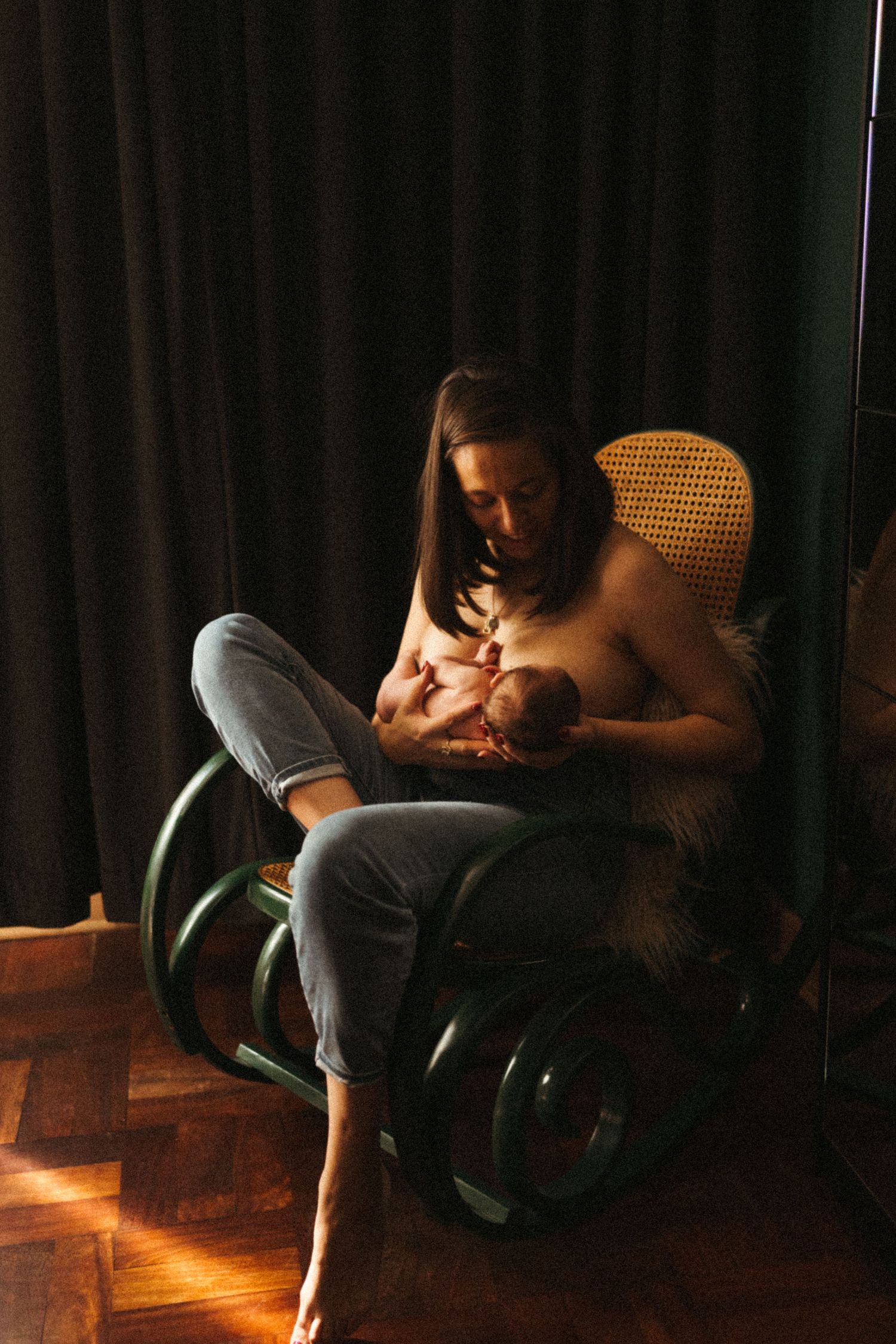 A quiet moment shared in a dimly lit room with wooden floors.