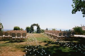 Panoramic view of an outdoor wedding ceremony setup with floral arch.