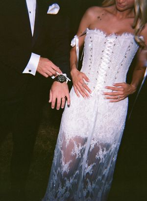Close-up of a white lace wedding dress with sheer details.
