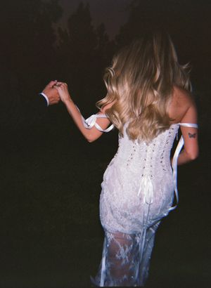 A lace wedding dress with corset back detailing shown at dusk.