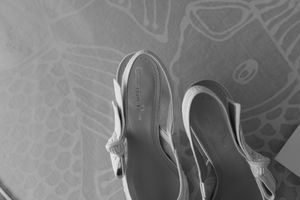 A row of elegant women's high heels in silver and metallic colors displayed against a patterned background.