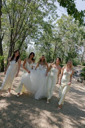 Group walking together under tree canopy in formal attire.