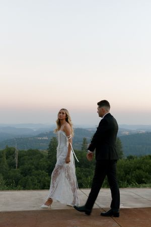 Couple dancing on an outdoor terrace with scenic mountain views at sunset.