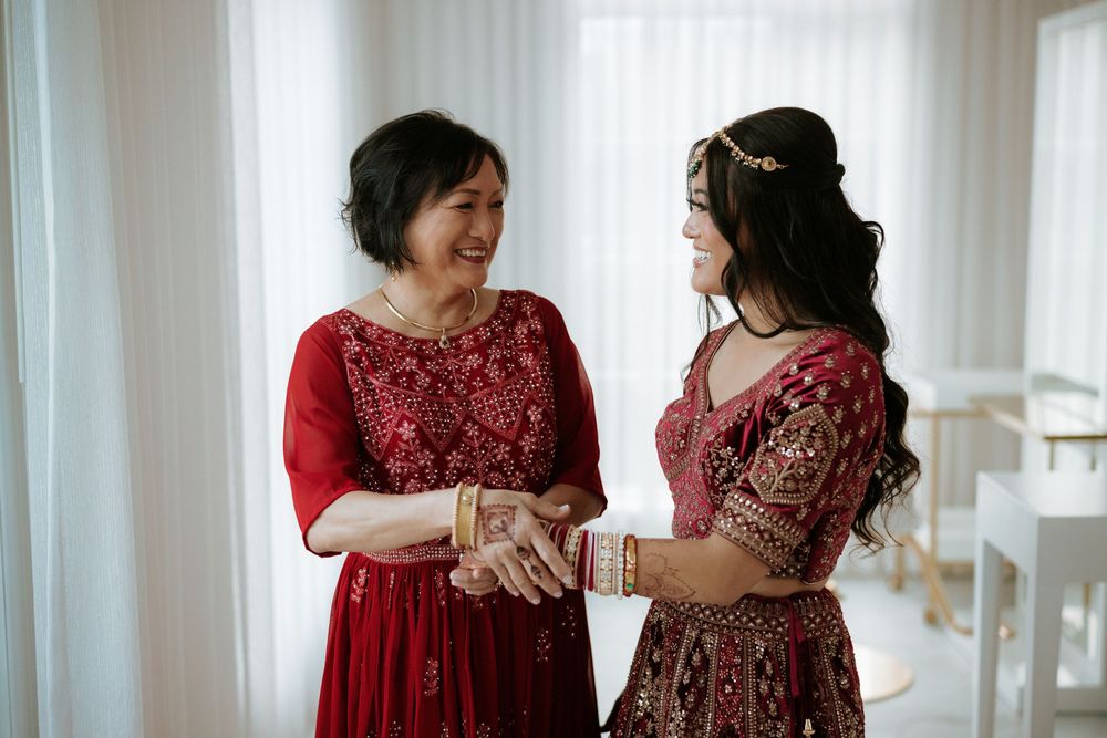 Two women in elegant red and burgundy formal dresses share a joyful moment together during a special occasion.at the Rockleigh, NJ