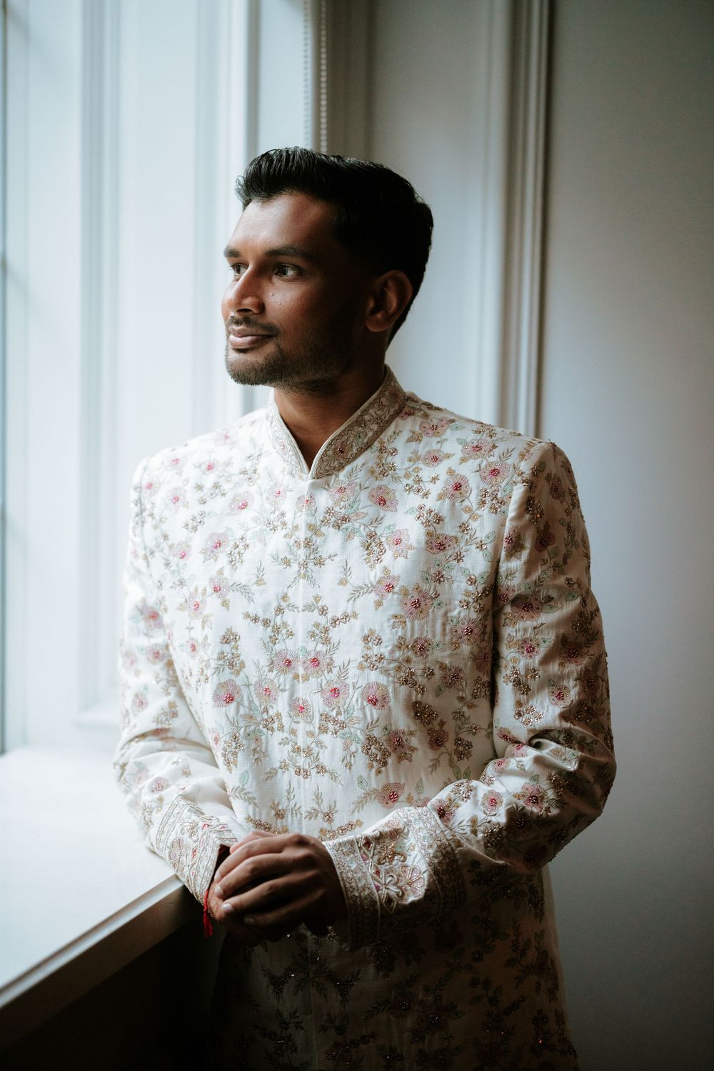 A person in a floral print shirt gazes thoughtfully through a window in a moody, atmospheric portrait series. at the Rockleigh, NJ