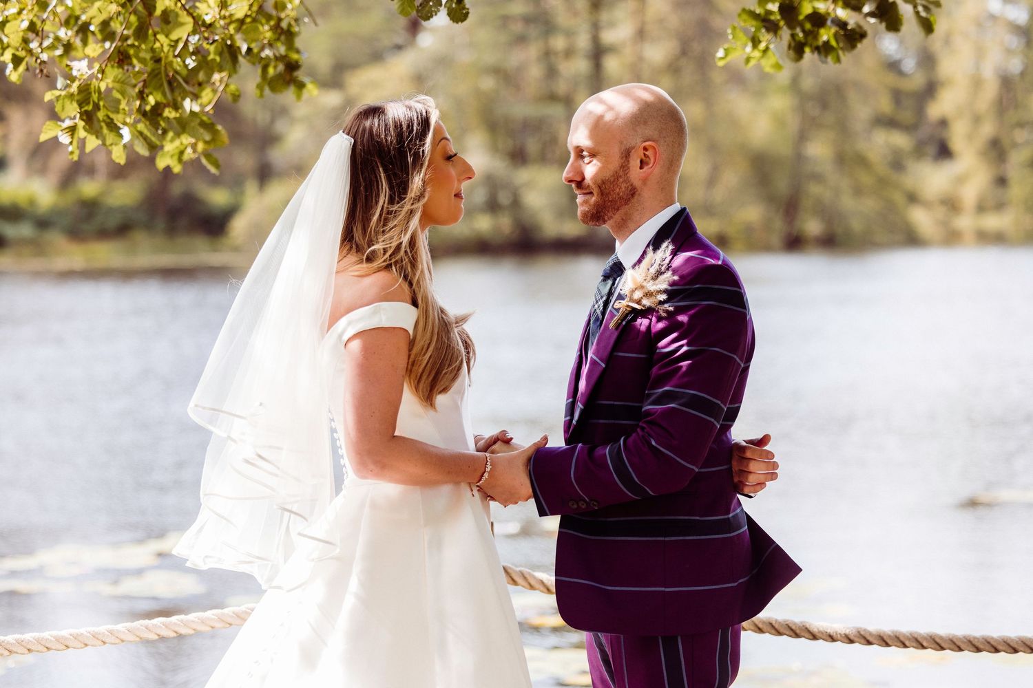 Bride and groom stare at each other contently as they say their vow by the lake at Gilpin Hotel and Lake House