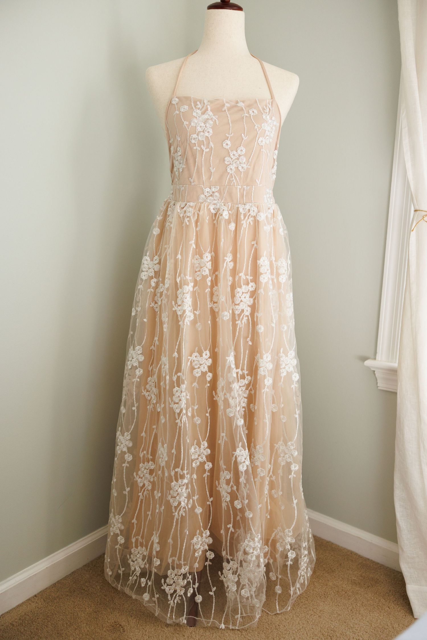 Vintage cream-colored maxi dress with puff sleeves and gathered neckline displayed on white mannequin against pale wall.