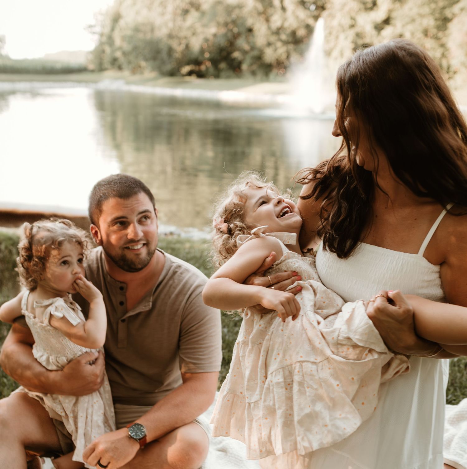 Family shares joyful moment together while sitting by waterfall.