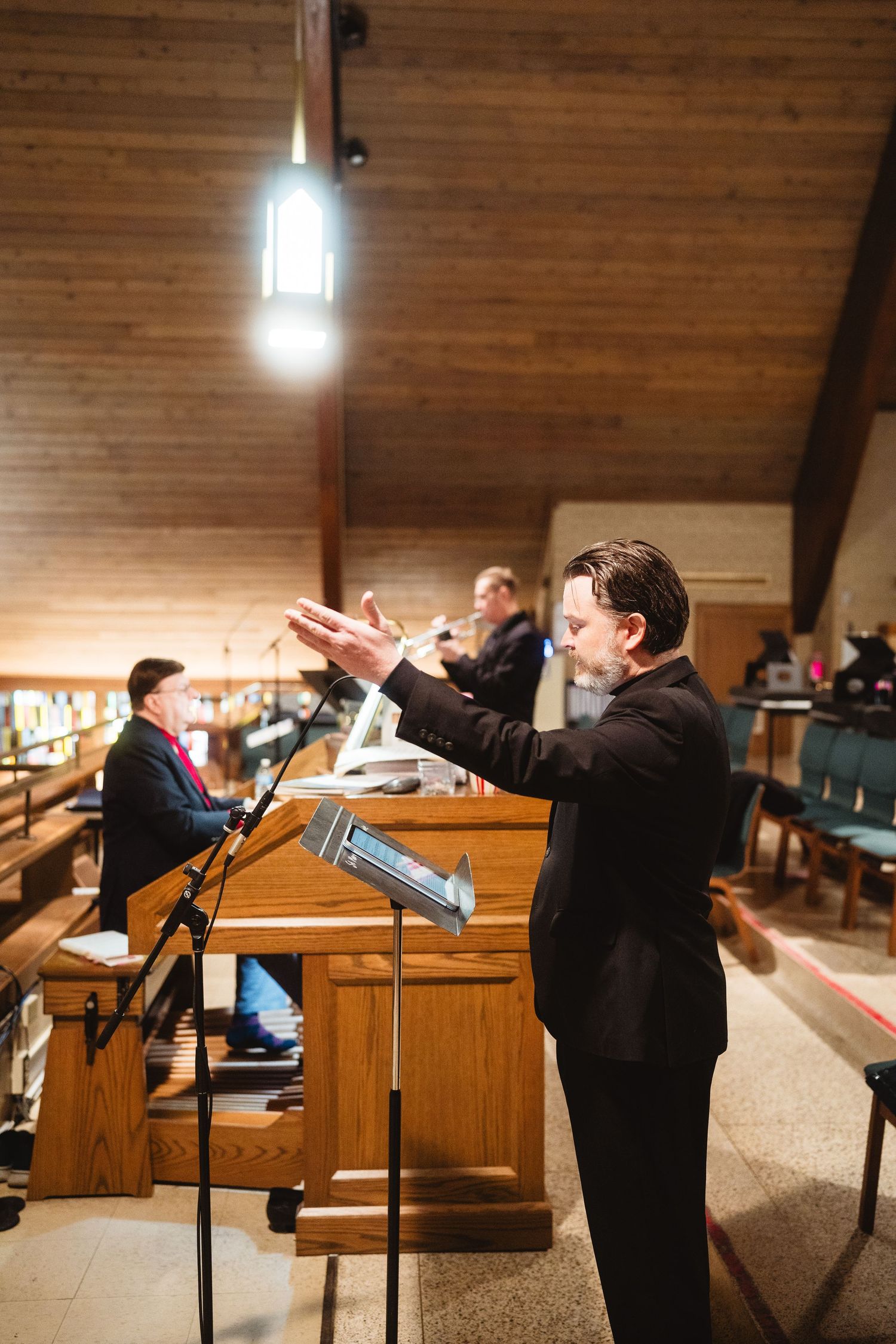 A sequence of four similar images showing a person at a wooden podium in what appears to be a church or auditorium.