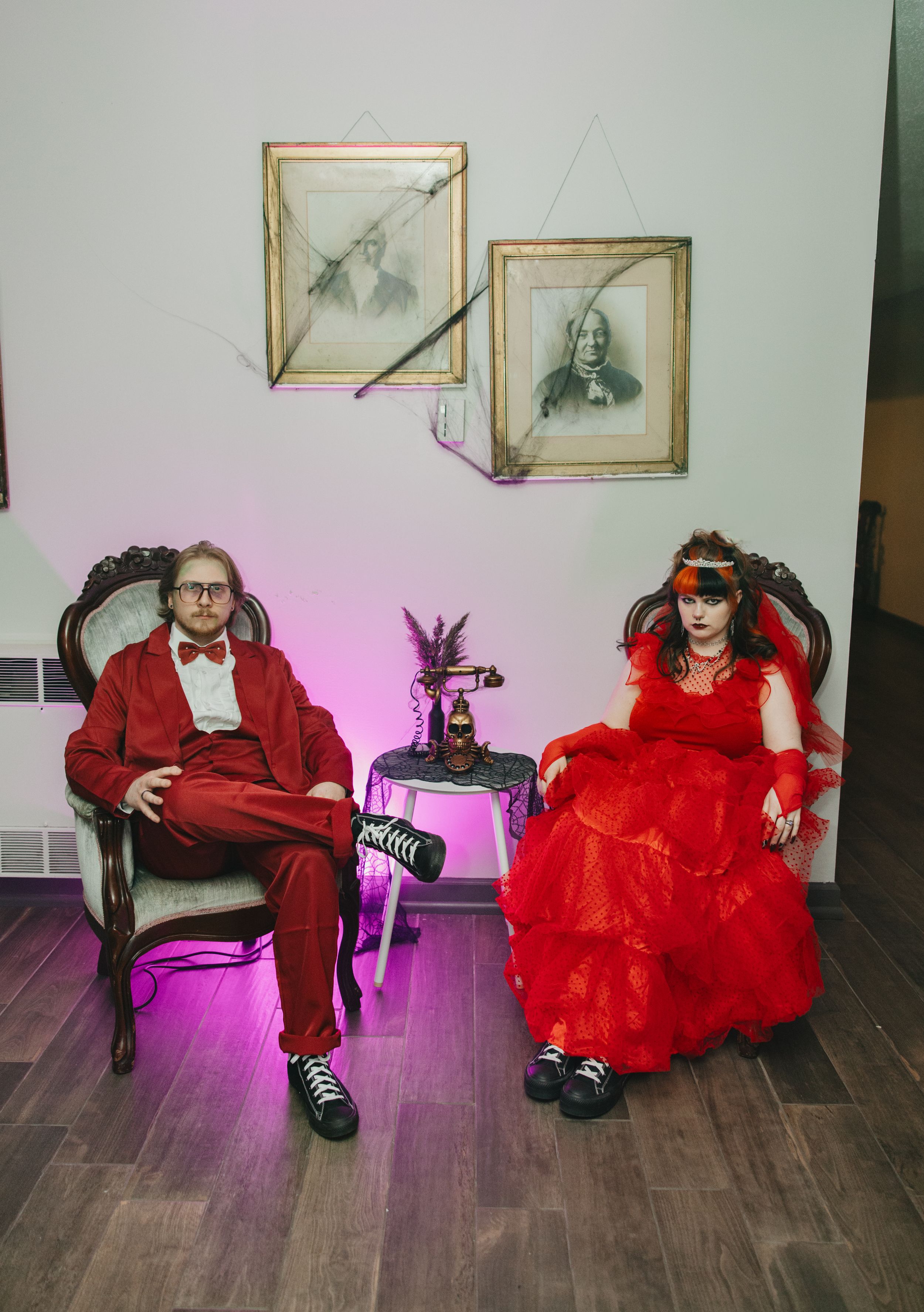 A sequence of photos showing a person in a red dress and another in a red suit sitting and posing on a wooden floor.