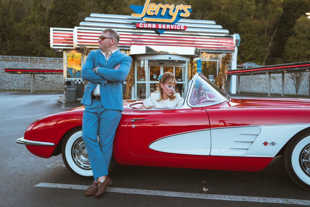 Classic red and white Chevrolet Corvette convertible parked at Jerry's Drive-In restaurant with vintage signage.