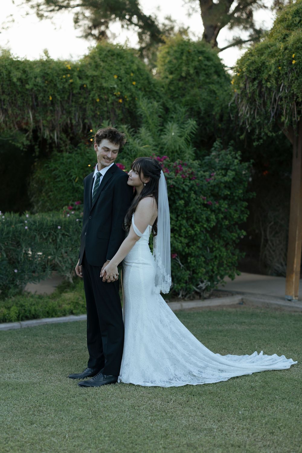 Bride and groom share an intimate moment on the lawn during their garden wedding photoshoot.