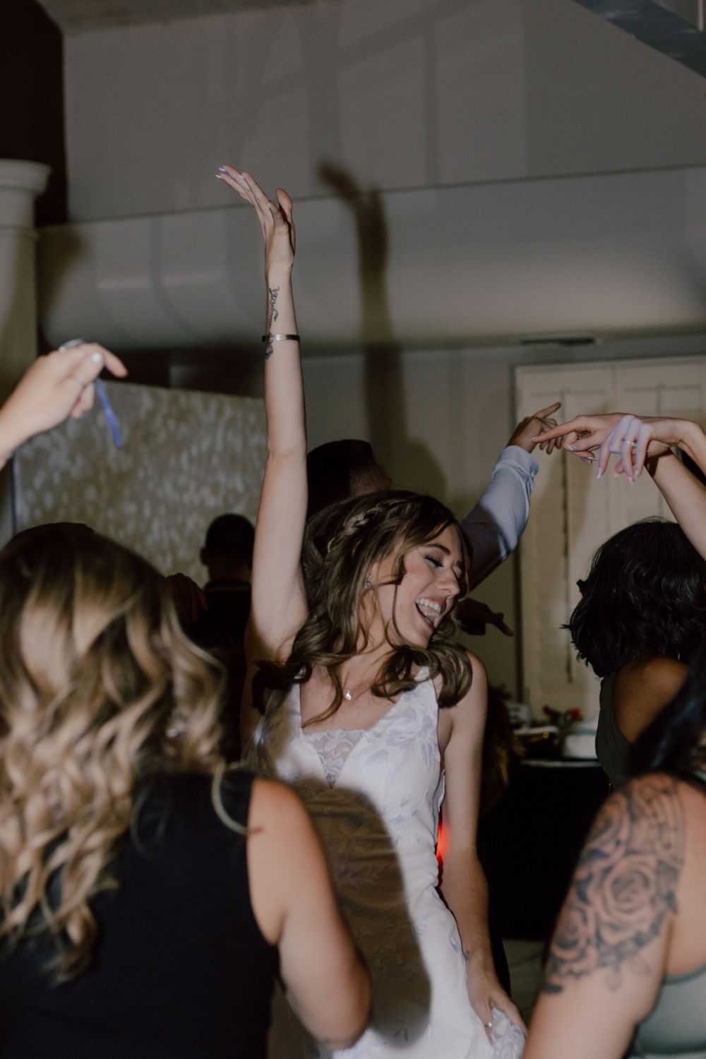 A bride dancing and celebrating with wedding guests on the dance floor.