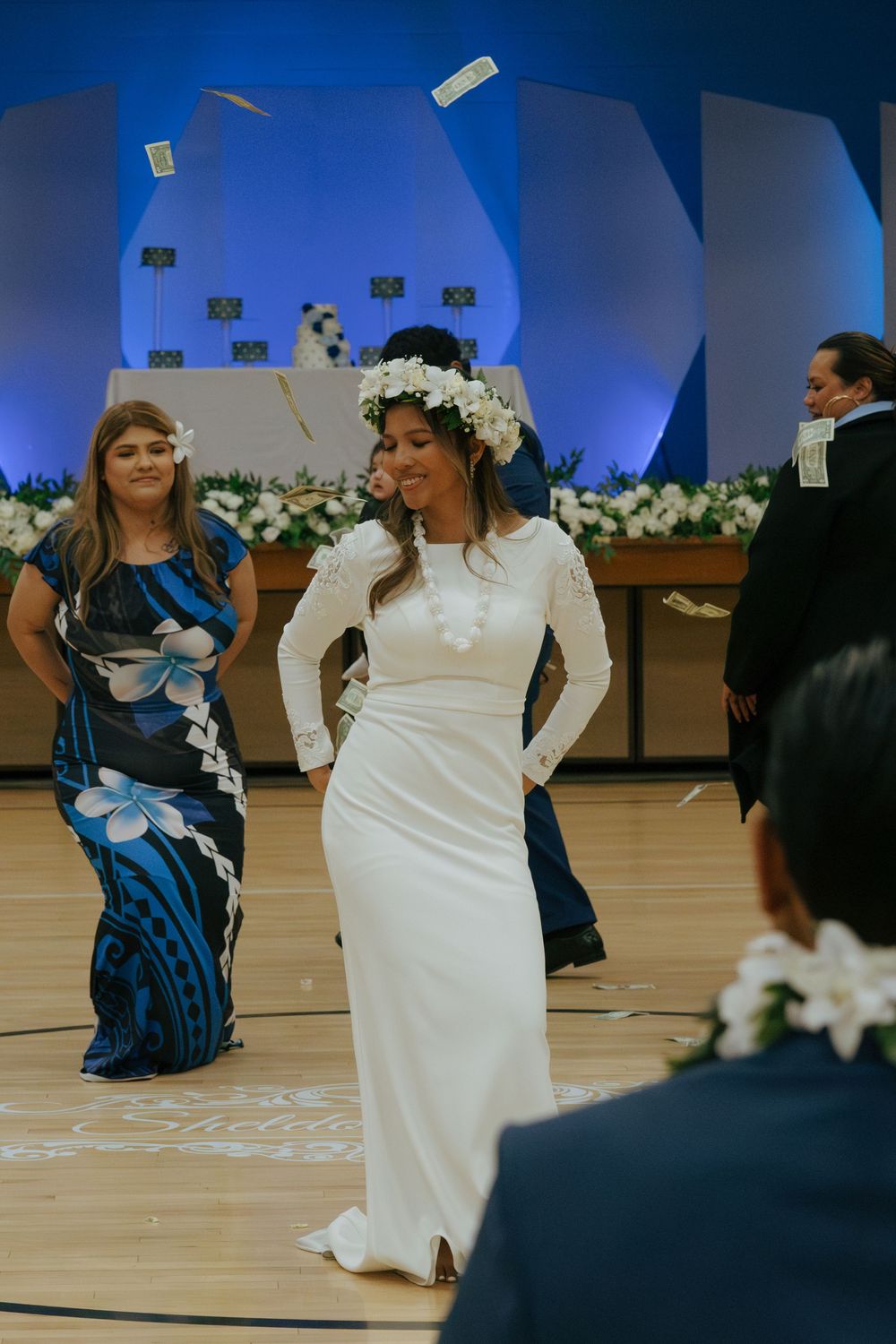 Money shower celebration at indoor event with people dancing and throwing cash.