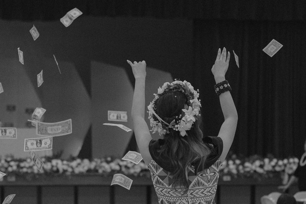 Money falling during celebratory event with party lights.