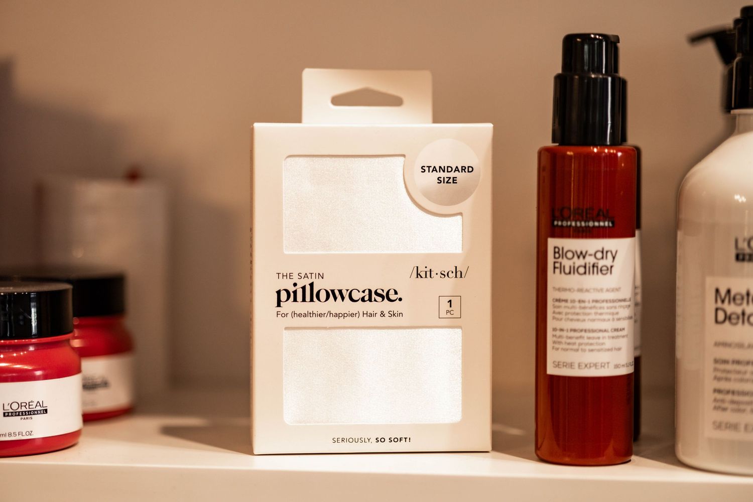 White Slip Silk pillowcase packaging box displayed on shelf alongside beauty and skincare bottles.