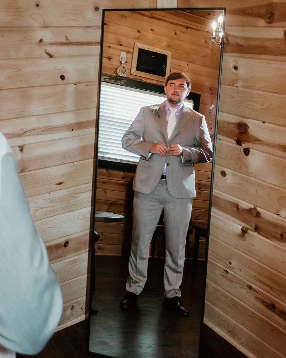 Wedding preparations in wood-paneled room with natural lighting.