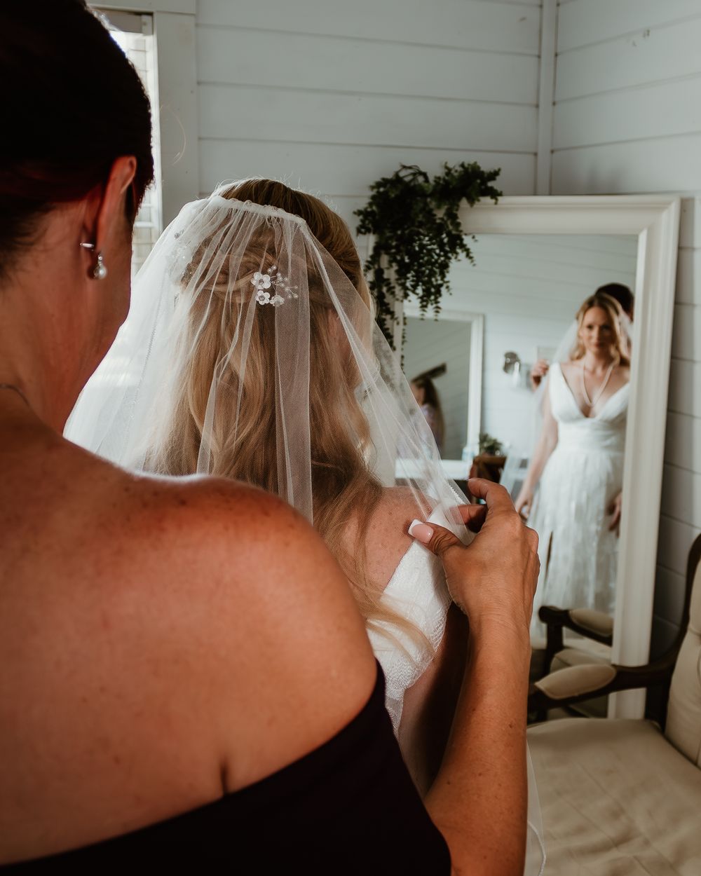Wedding preparations with bride in white dress and veil.