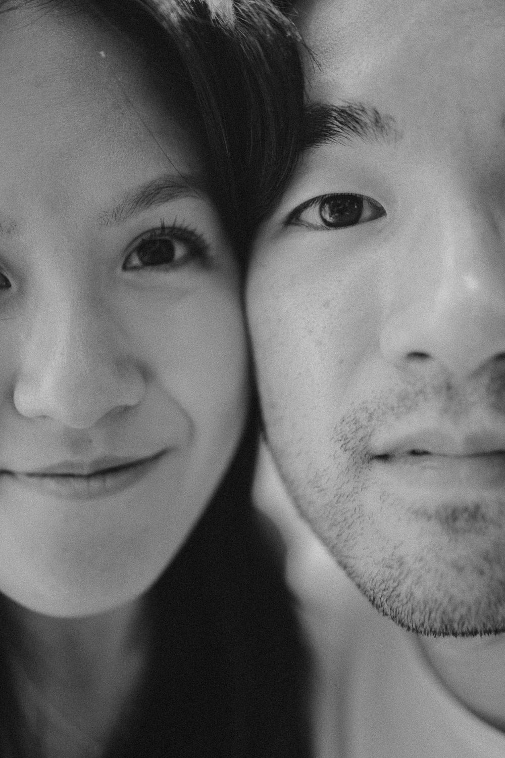 A series of black and white close-up portraits showing partial faces with gentle smiles and expressions.