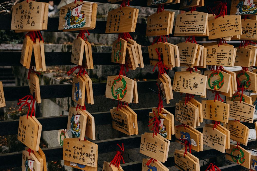 Wooden prayer tablets with Japanese writing hanging at a Shinto shrine.
