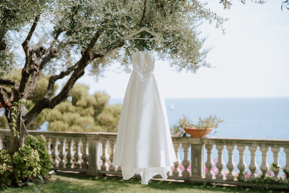l'abito della sposa fotografato nella terrazza del giardino della location villa casa rossa ad imperia, sullo sfondo la vista mare.