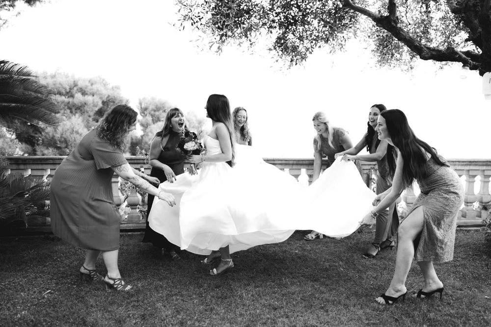 le damigelle sistemano l'abito della sposa a villa casa rossa ad imperia prima del rito civile del matrimonio.
