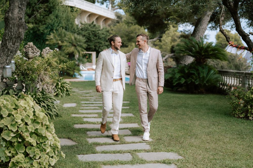 lo sposo e il suo testimone camminano nel giardino di villa casa rossa a imperia prima della cerimonia del matrimonio con rito civile.