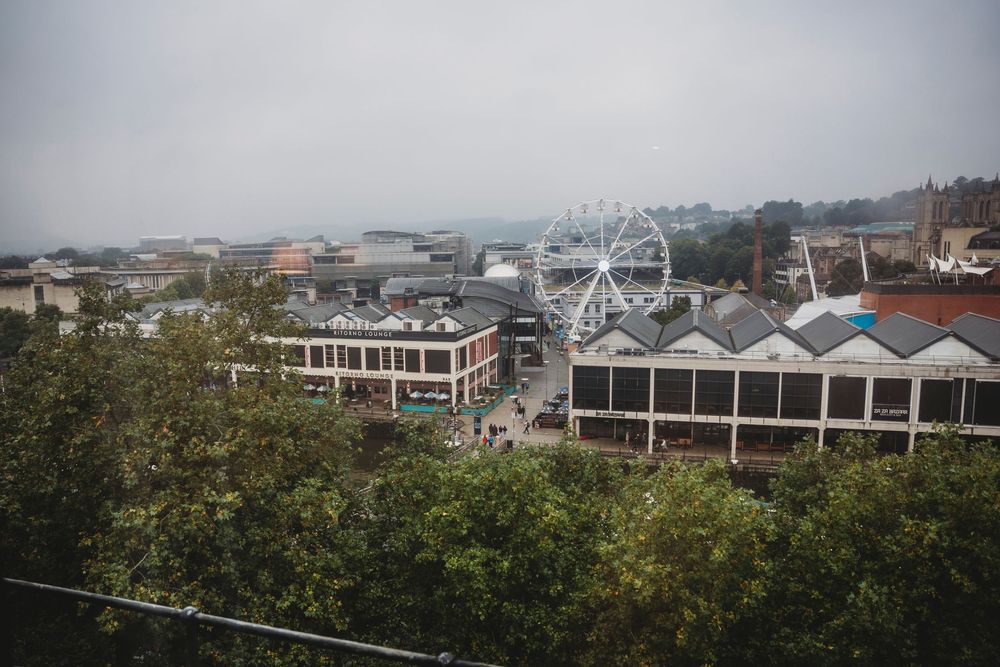 Aerial view of a coastal town with a Ferris wheel visible in the distance.