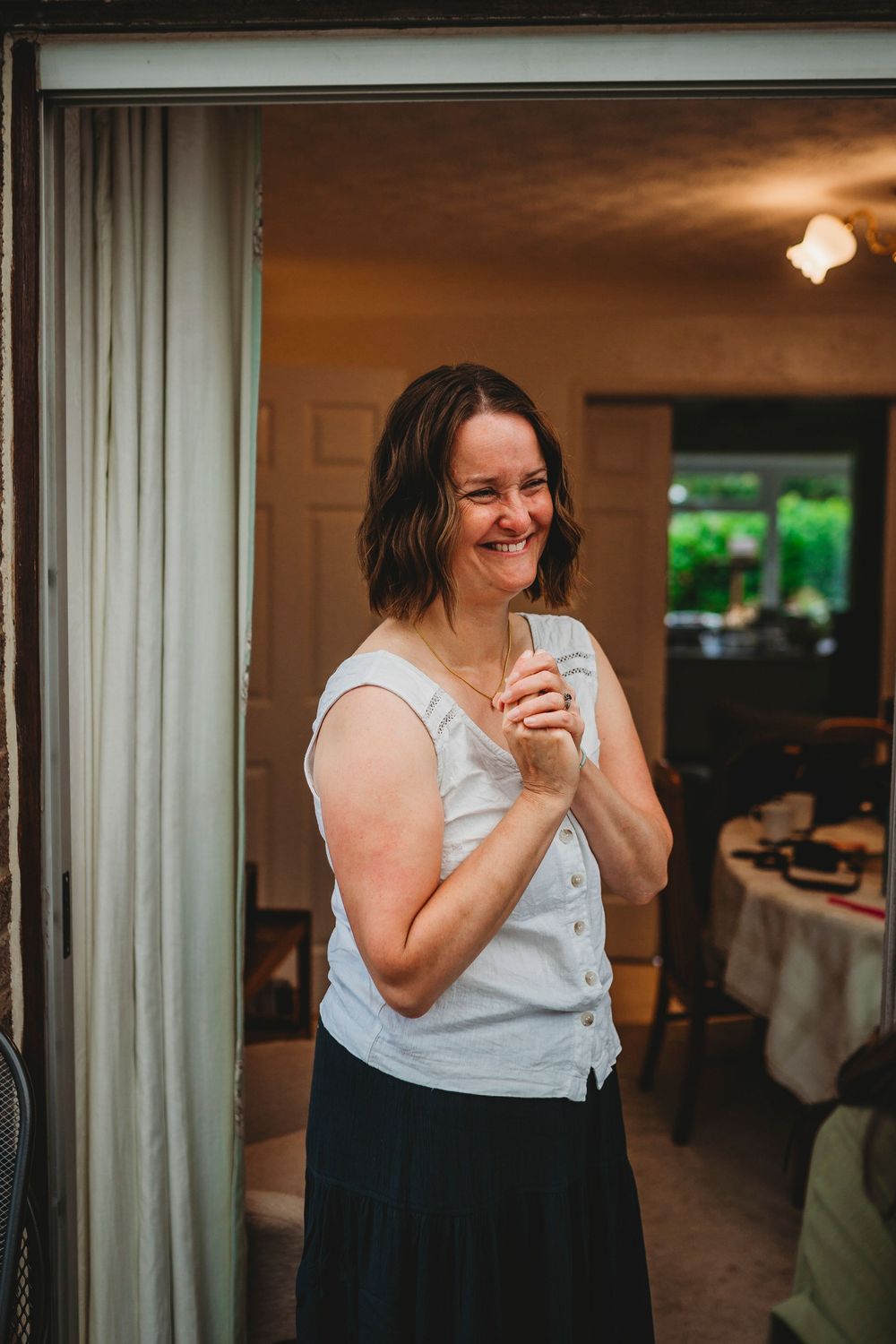 Candid sequence of joyful reactions in a white and black outfit at an indoor venue.