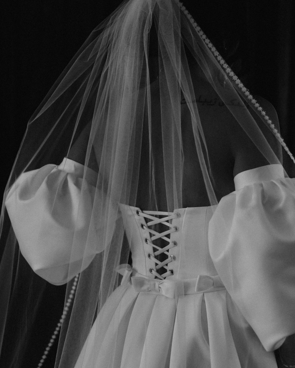 Detail shots of a classic white wedding dress with lace-up back and flowing veil.