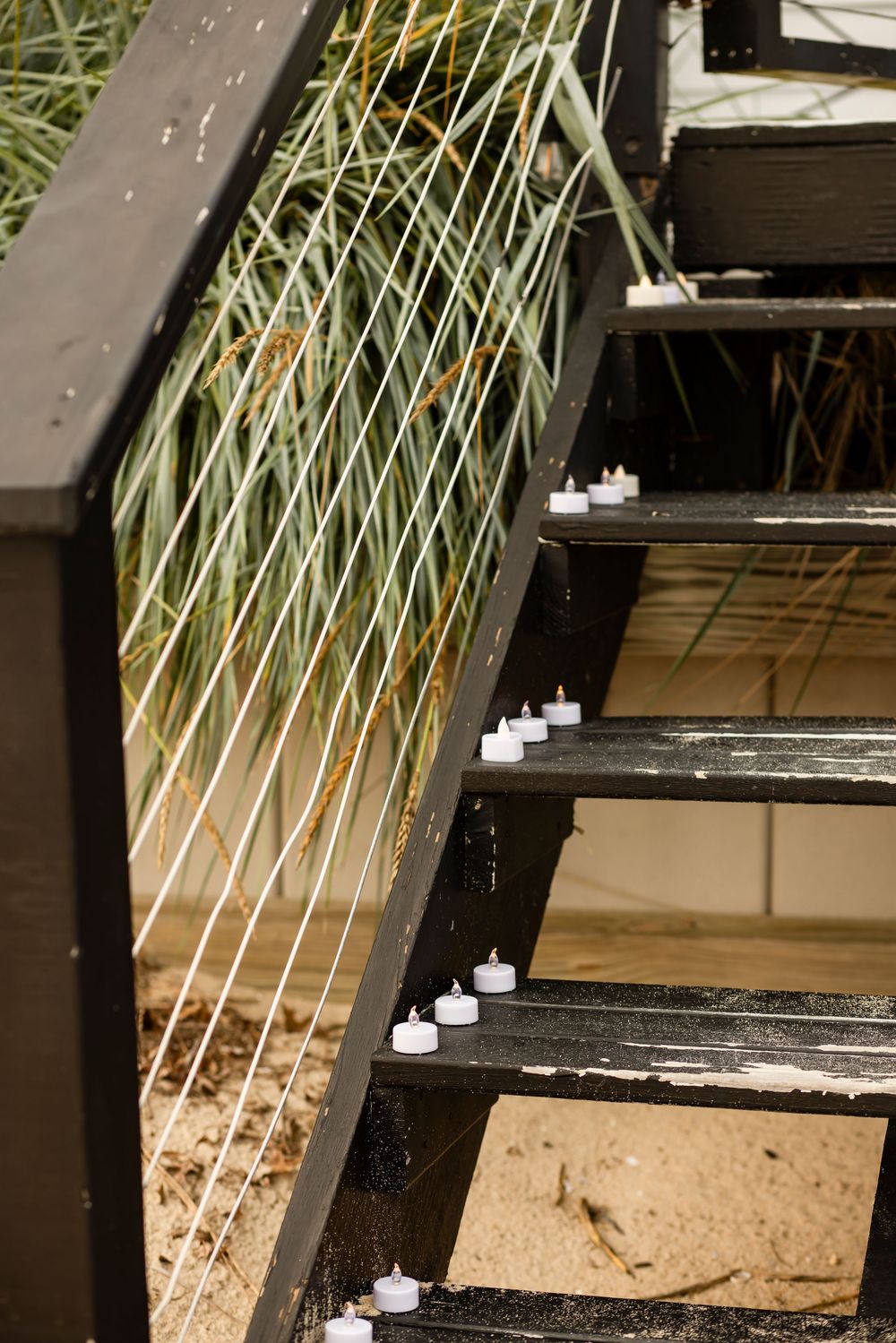 Close-up view of a wooden deck or boardwalk with white railings and tropical palm fronds visible above.