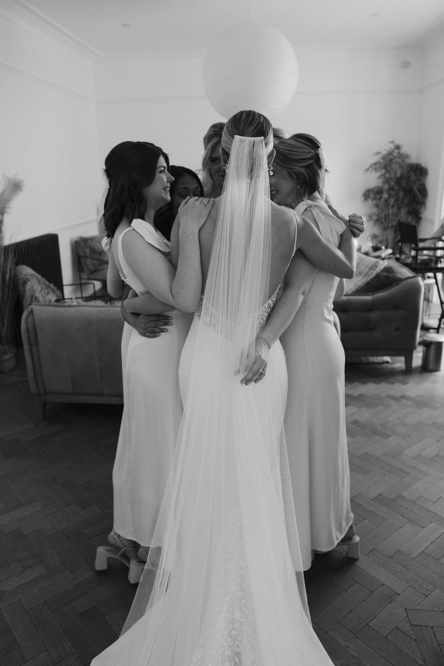 Tunnels Beach Wedding Venue in North Devon, Bride hugging bridesmaids