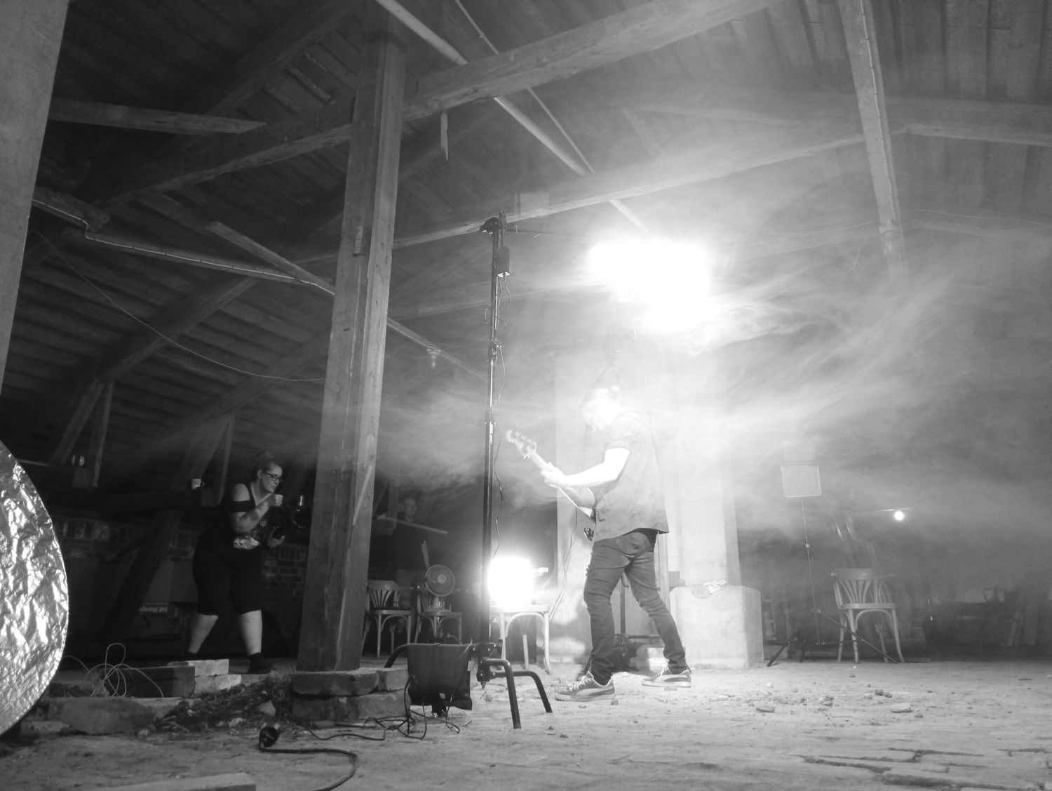 Atmospheric warehouse scene with bright backlighting creating dramatic silhouettes and smoke effects.