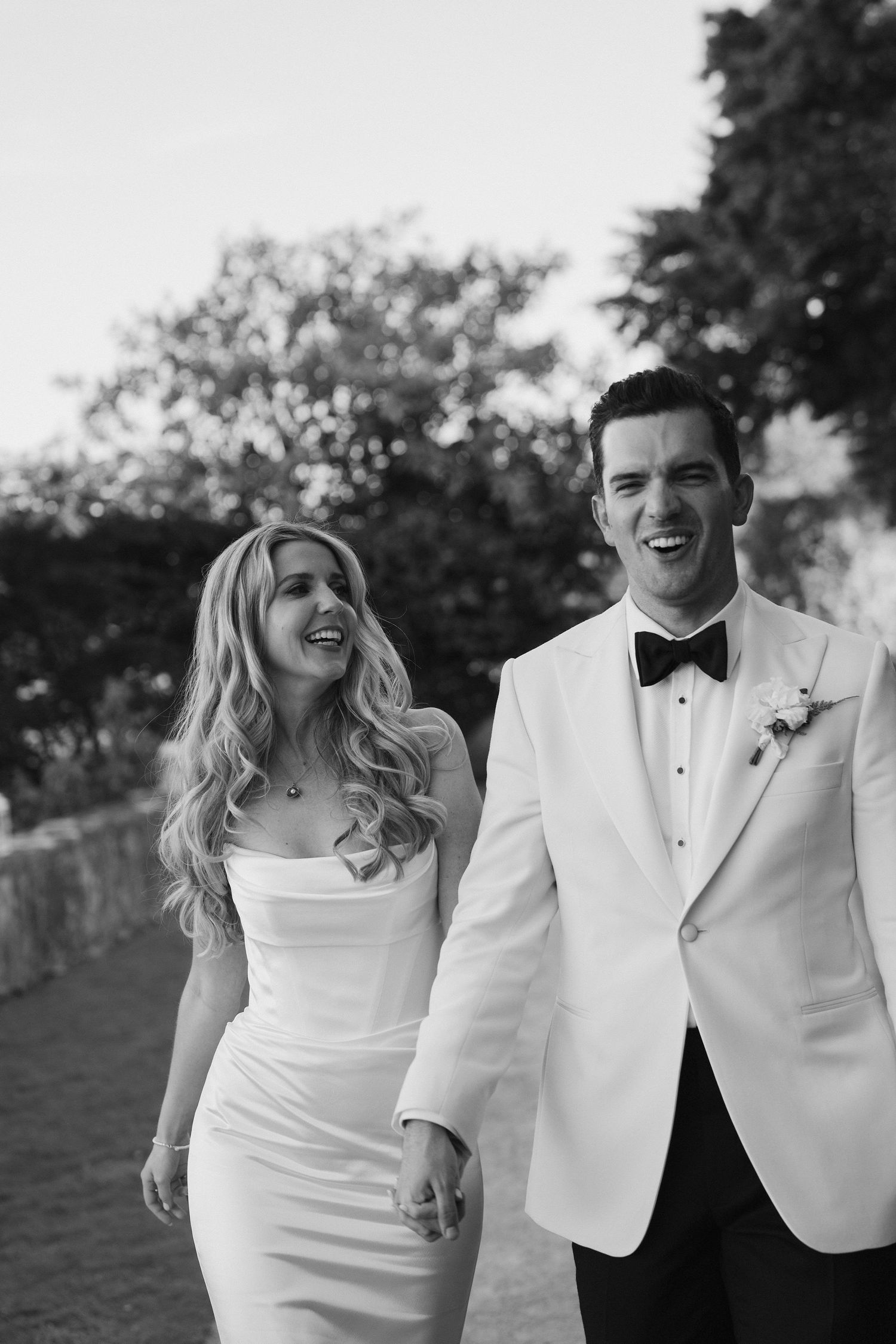 bride and groom walking and laughing at hamswell house wedding in bath