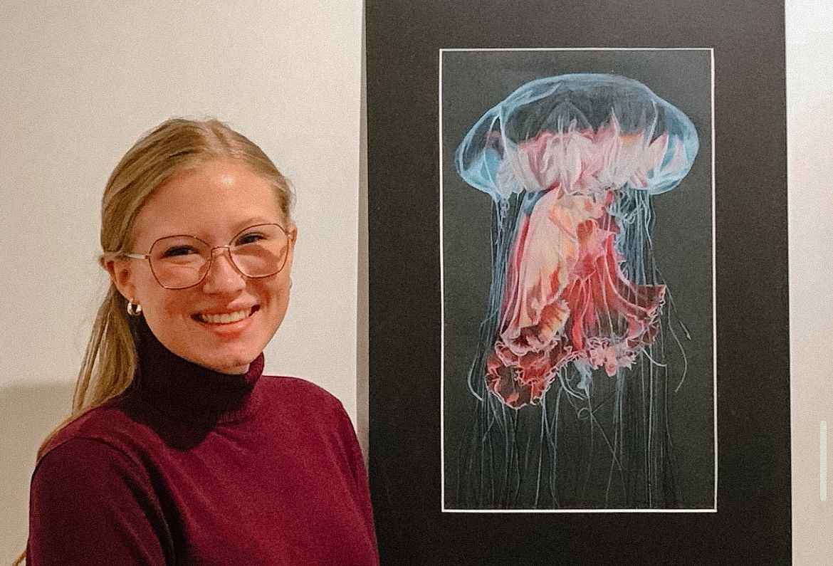 Gallery wall featuring multiple framed jellyfish photographs in pink and blue hues.