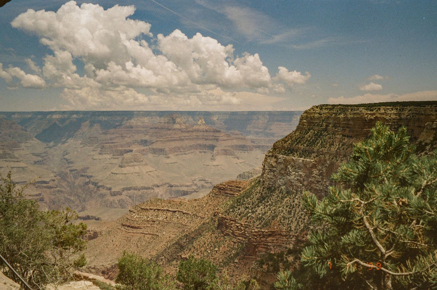 Majestic view of the Grand Canyon's deep gorges and rock formations under blue skies.