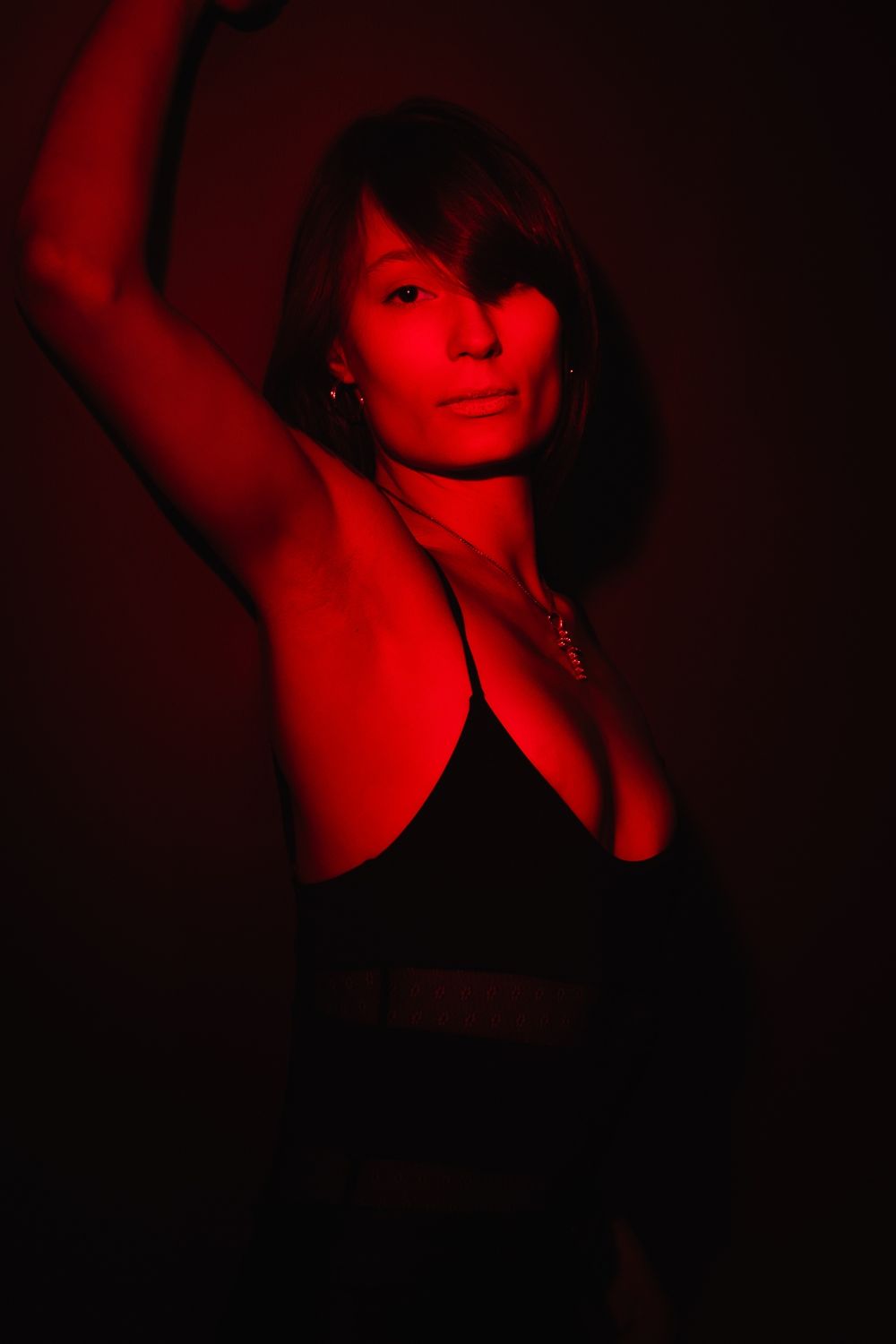 Artistic portrait series in dramatic red lighting showing silhouetted figure in moody, dark atmosphere.