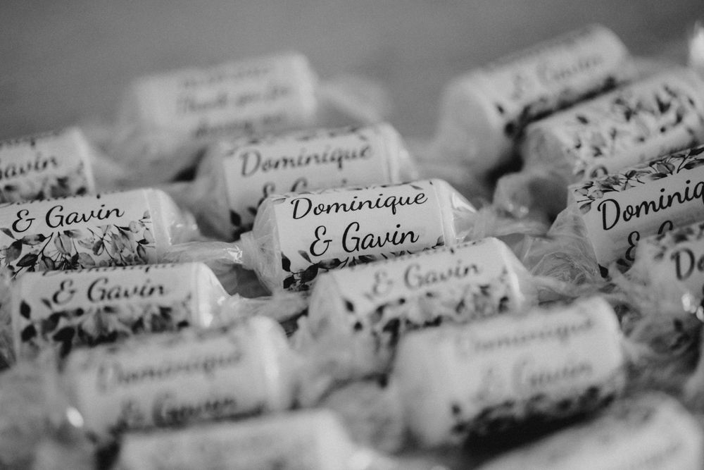 Black and white close-up of handwritten paper name tags labeled Dominique Le Gavrin arranged in rows.