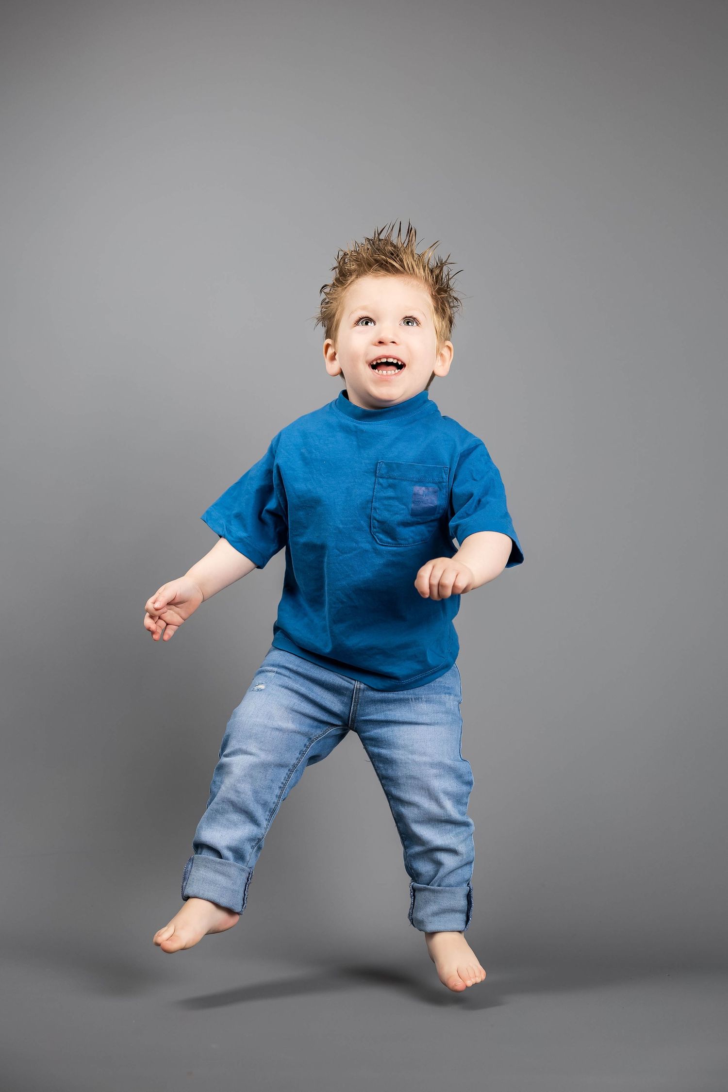 2 year old boy photo on the grey background jumping