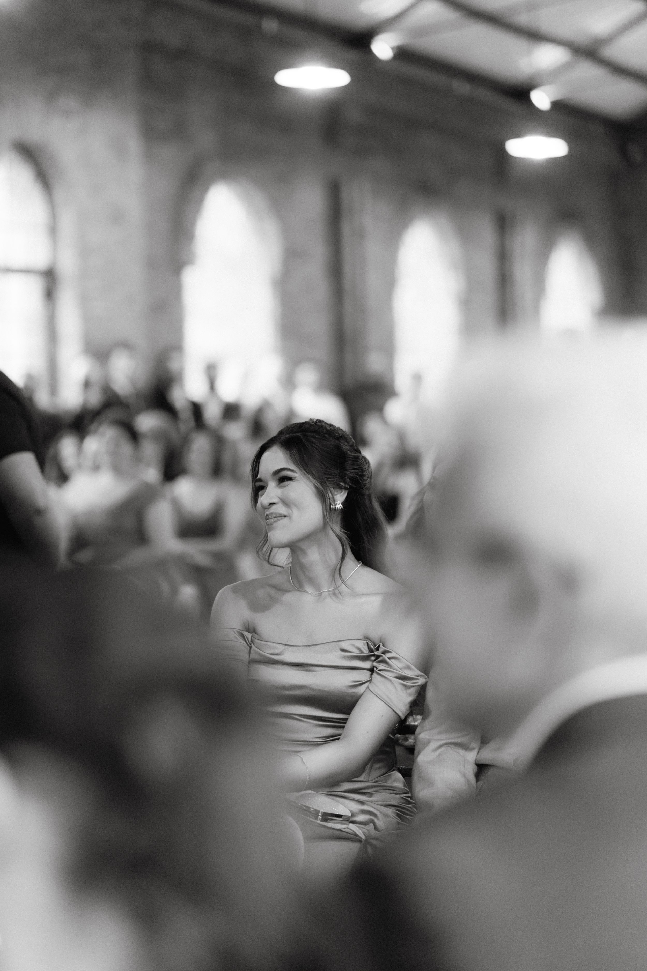 Black and white photo captures bridesmaid's emotional reaction during wedding ceremony.
